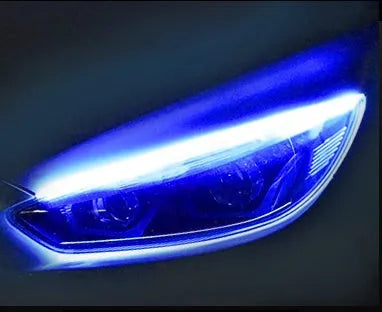 Slim silicone car LED daytime running light strip with flowing turn signal effect on a vehicle headlight.
