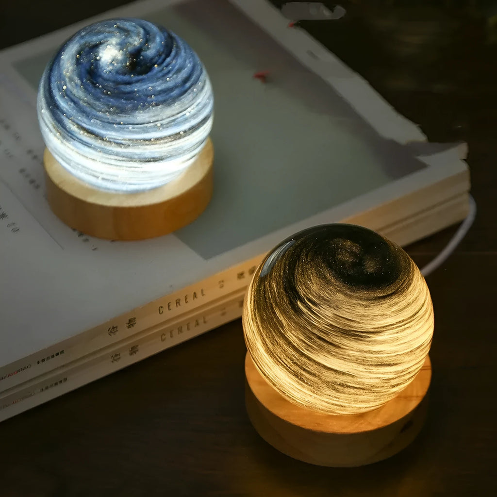 Planet model night light with USB cable and base, showing three colour lighting options.