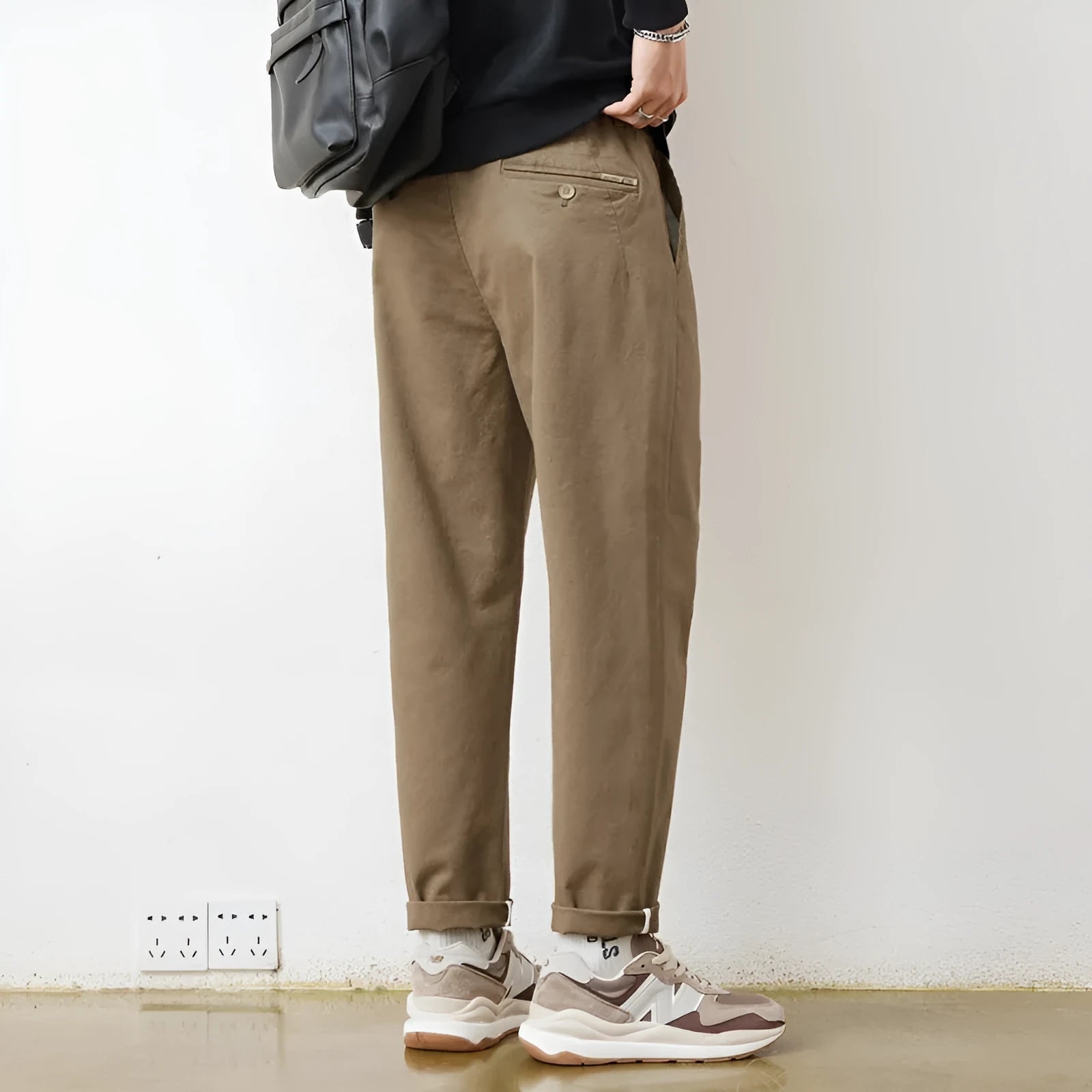 Men's loose wide-leg casual pants in dark khaki with zipper fly and mid-rise waist on a plain background