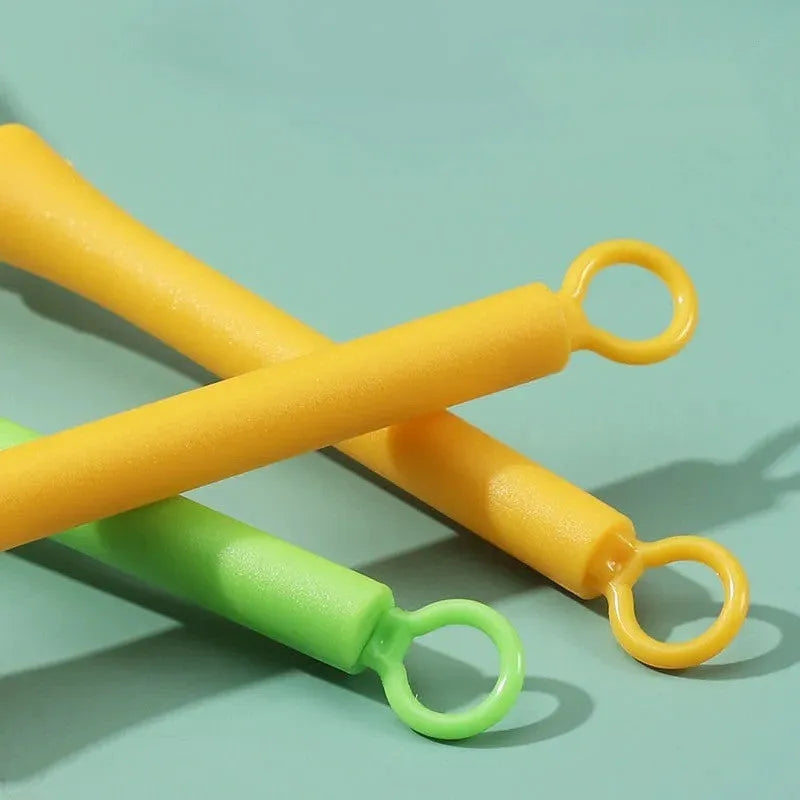 Plastic mini manual eggbeater in green for stirring batter in a kitchen