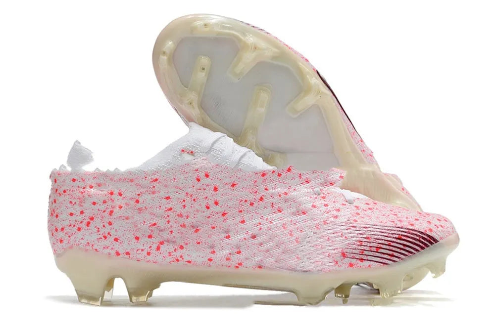 Men's black football shoes with knitted upper, FG studs, and lace-up closure shown on grass surface