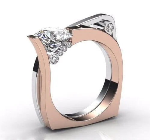 Rose gold geometric couple ring with a central inlaid zircon stone on a grey background.
