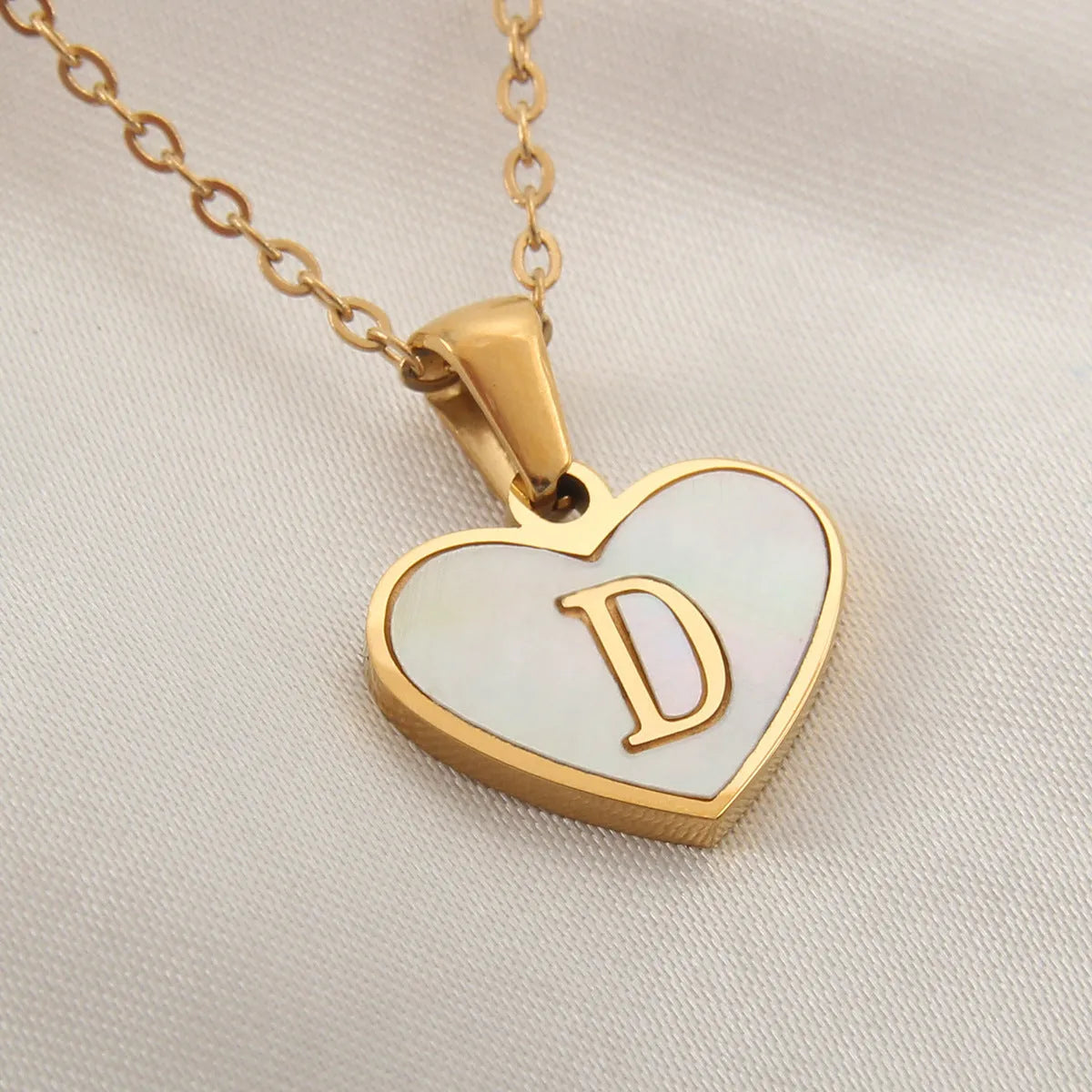 Gold plated chain necklace with a white shell heart-shaped pendant personalised with a single letter initial.