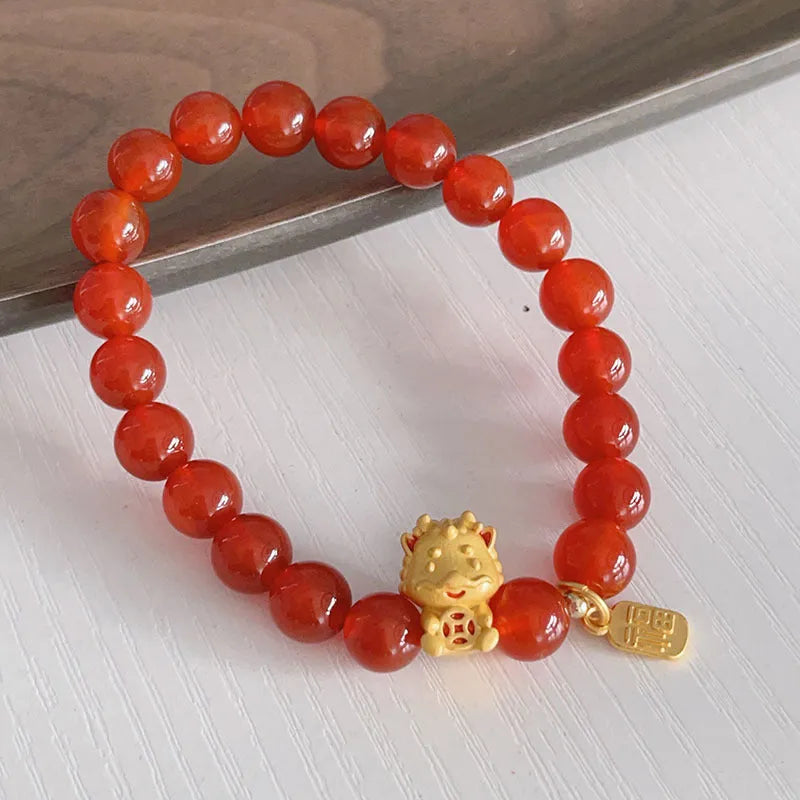 Close-up of a red agate bracelet with a Chinese dragon design on a woman's wrist.