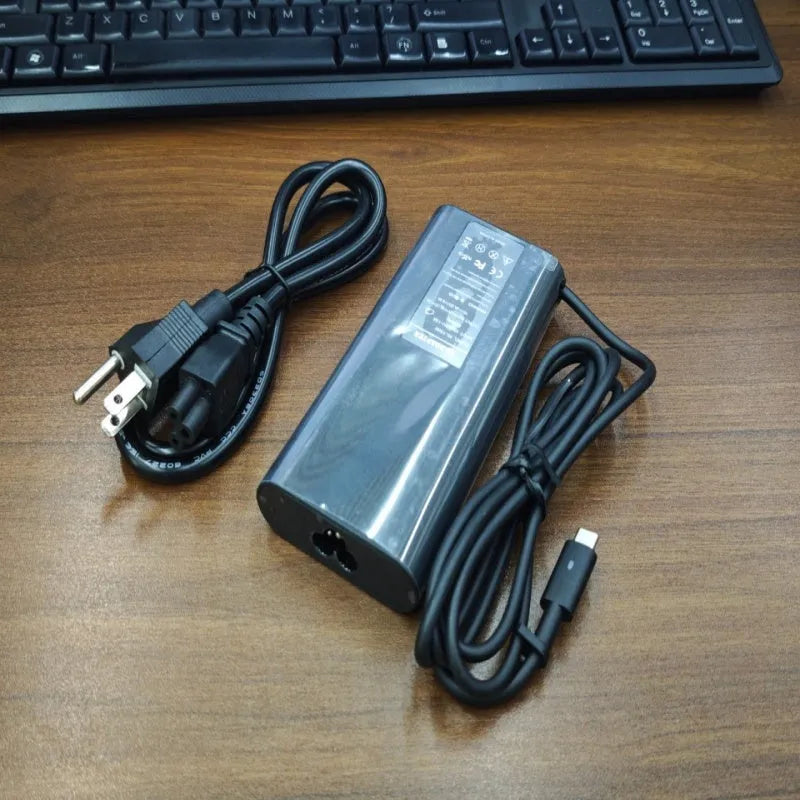 Black oval 65W Type-C laptop power adapter with multiple international plug configurations