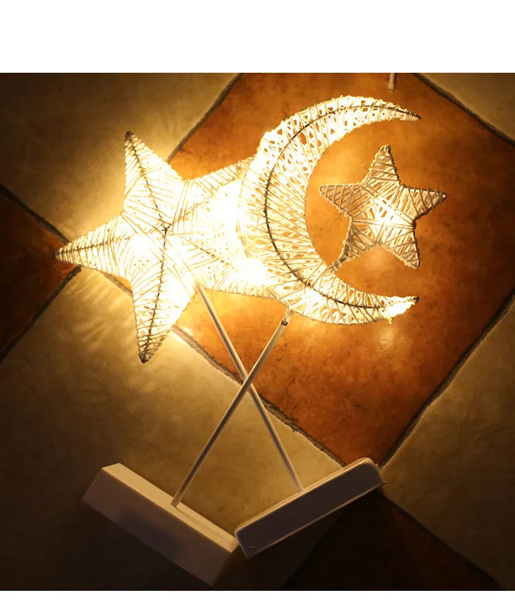 Rattan woven star-shaped LED table lamp with copper wire details on a table.