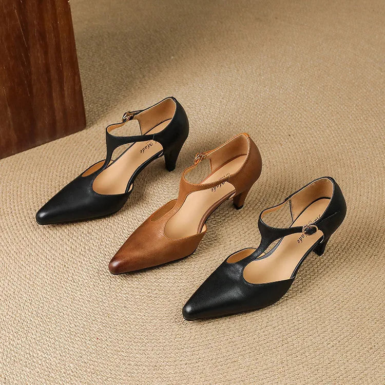Brown retro women's sandals with T-strap, closed round toe, and a stout heel on a wooden background.
