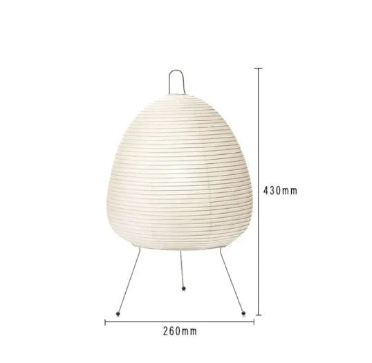 Japanese style table lamp with handmade paper shade and aluminium base on a wooden surface.