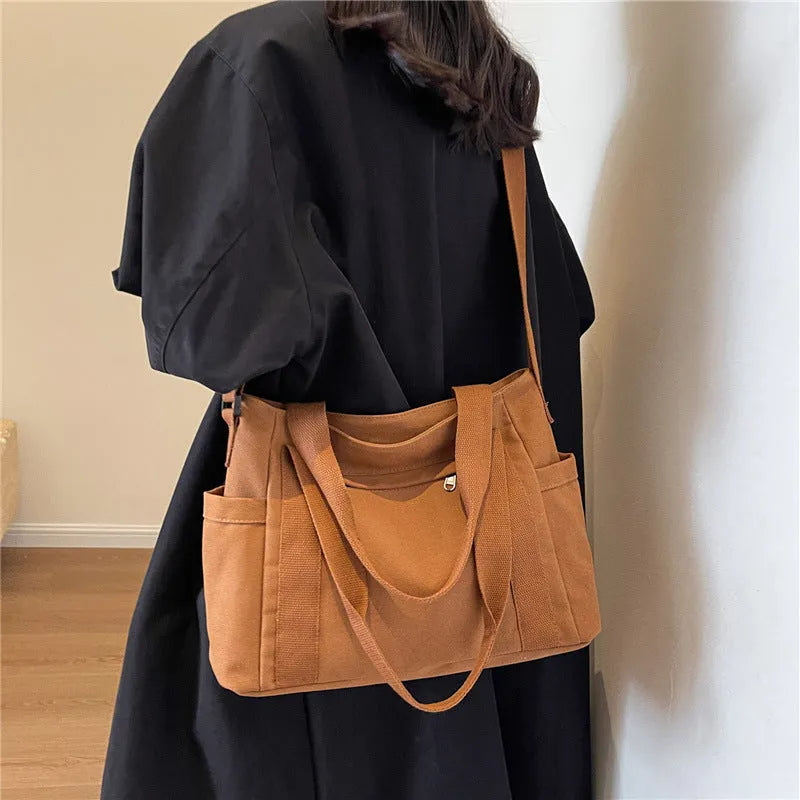 Women's large capacity canvas shoulder bag in solid colour with outer pocket and internal phone compartment