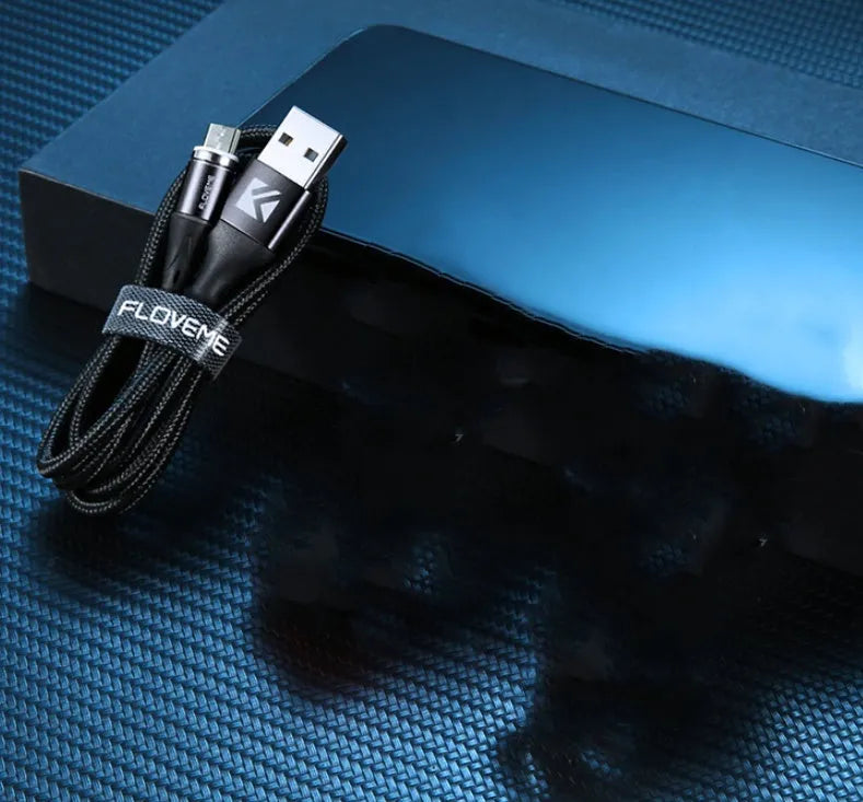 Black magnetic fast charge data cable with illuminated side lights and interchangeable connectors on a table.