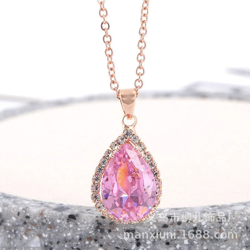 Close-up of a women's pink rose gold drop necklace with geometric rhinestone patterns on an alloy setting.