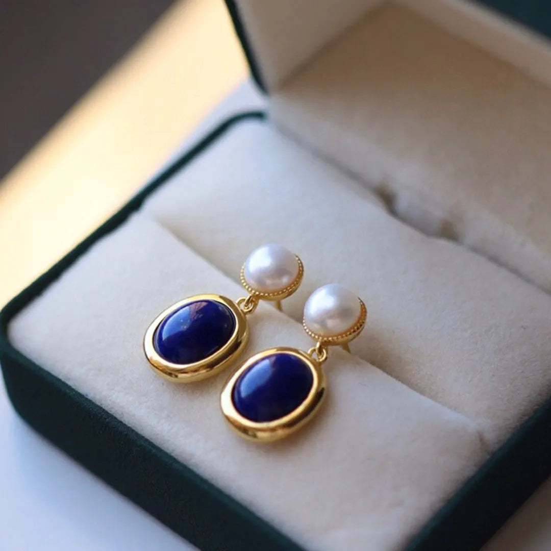 A pair of simple 925 silver stud earrings with a blue lapis lazuli pearl and auspicious patterns.
