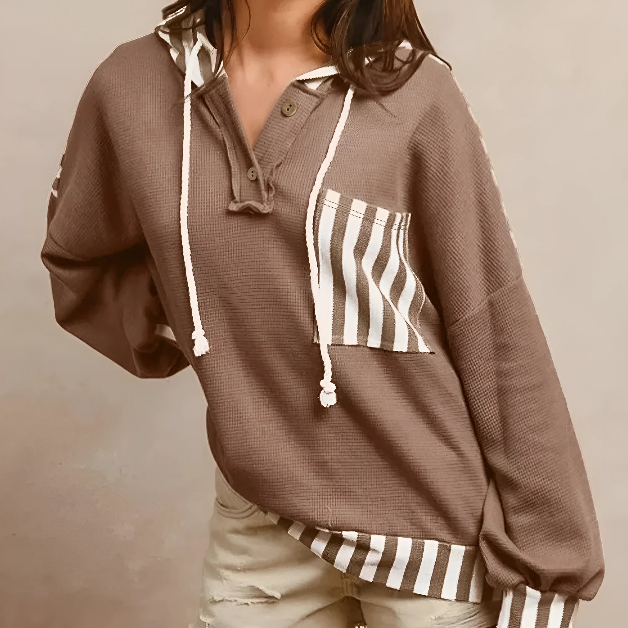 Straw yellow hoodie with waffle texture and striped patchwork design, showing front drawstring and button neck.