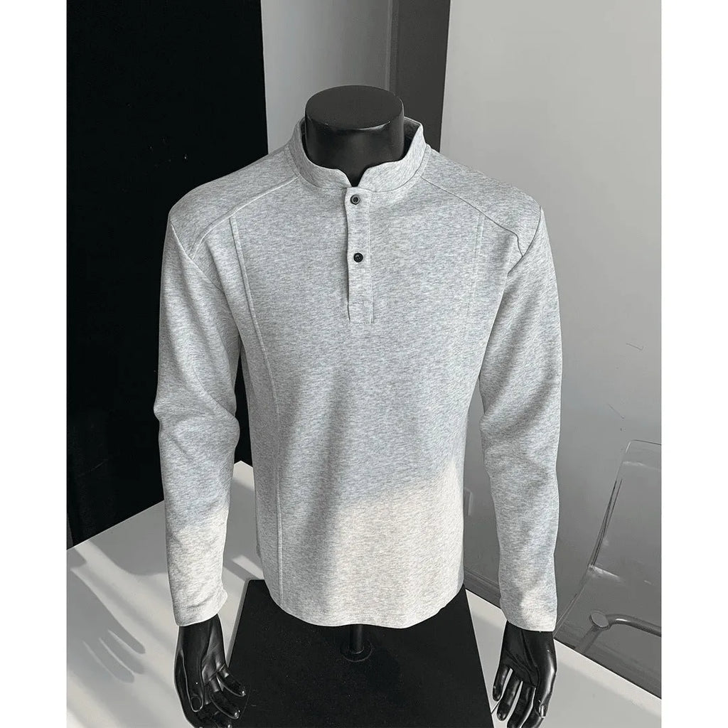 Men's black asymmetric patchwork long sleeve polo shirt with a stand-up collar, laid flat.