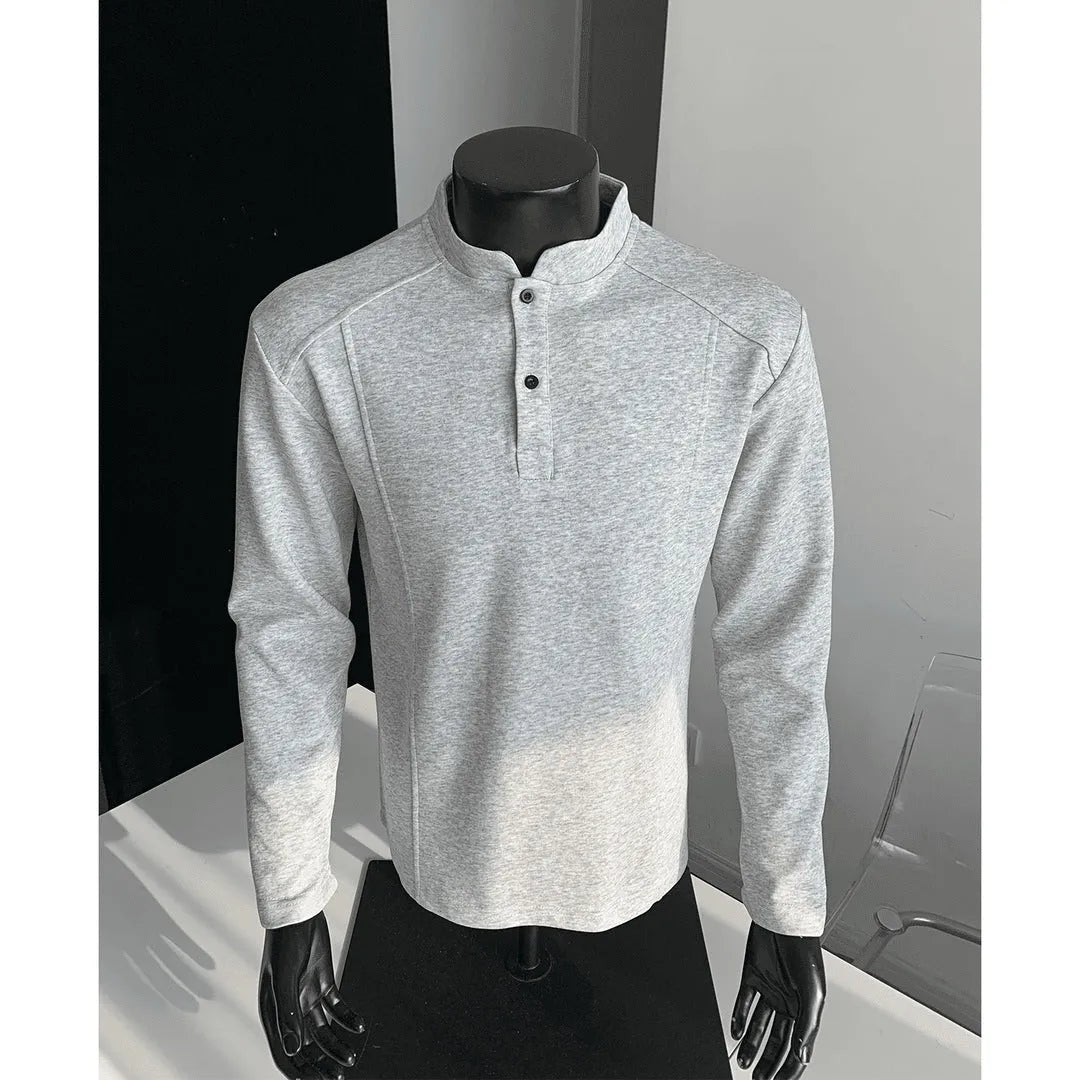 Men's black asymmetric patchwork long sleeve polo shirt with a stand-up collar, laid flat.