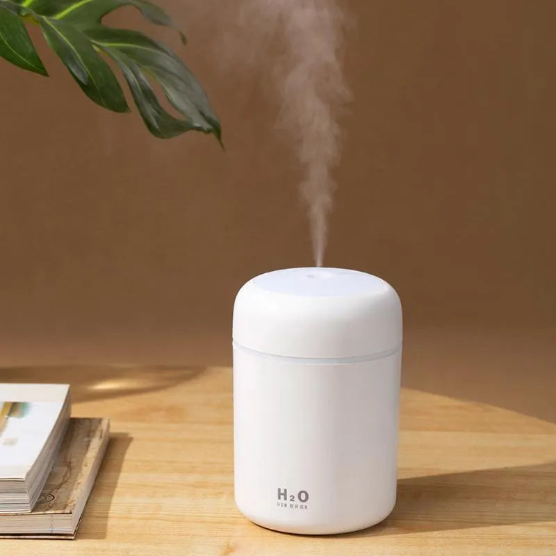 Pink USB desktop humidifier with colourful lights and 300ml water tank on wooden surface