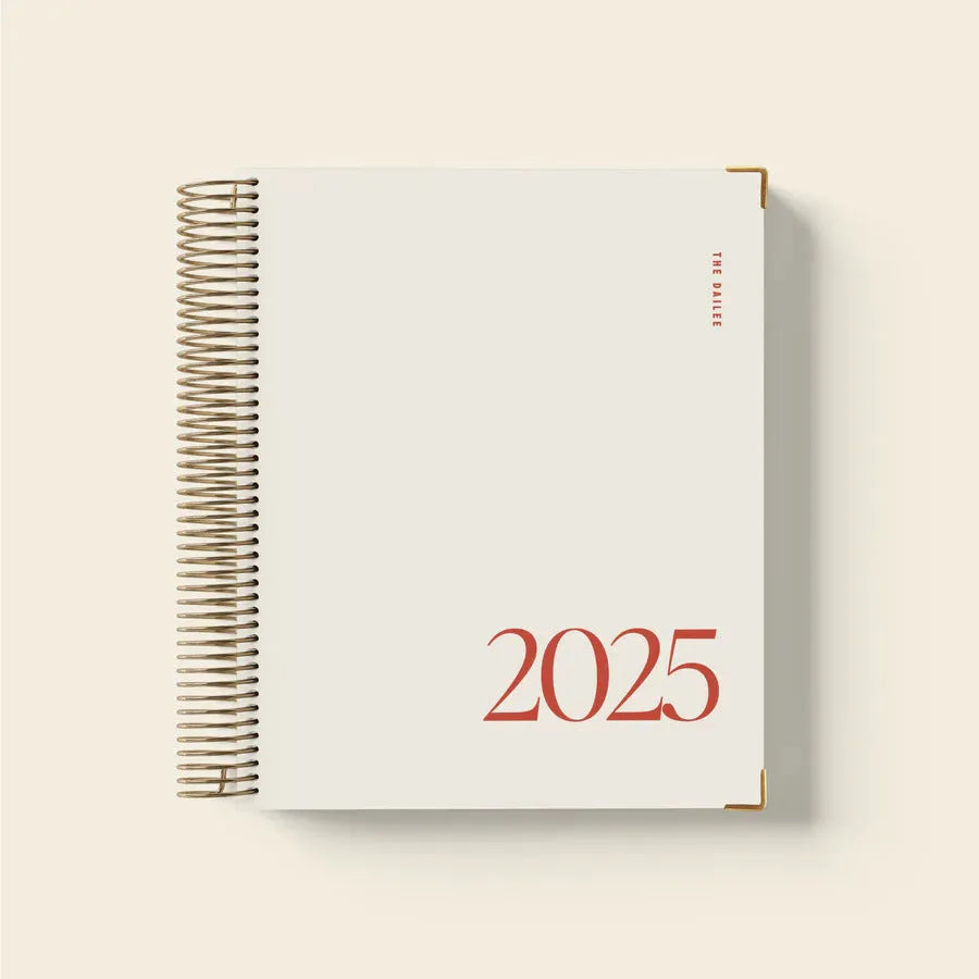 Cherry red A5 coil notebook open on a desk, showing spiral binding and lined paper