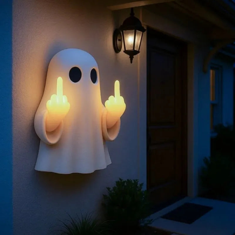 Small white ghost statue night lamp on a shelf for Halloween decor.