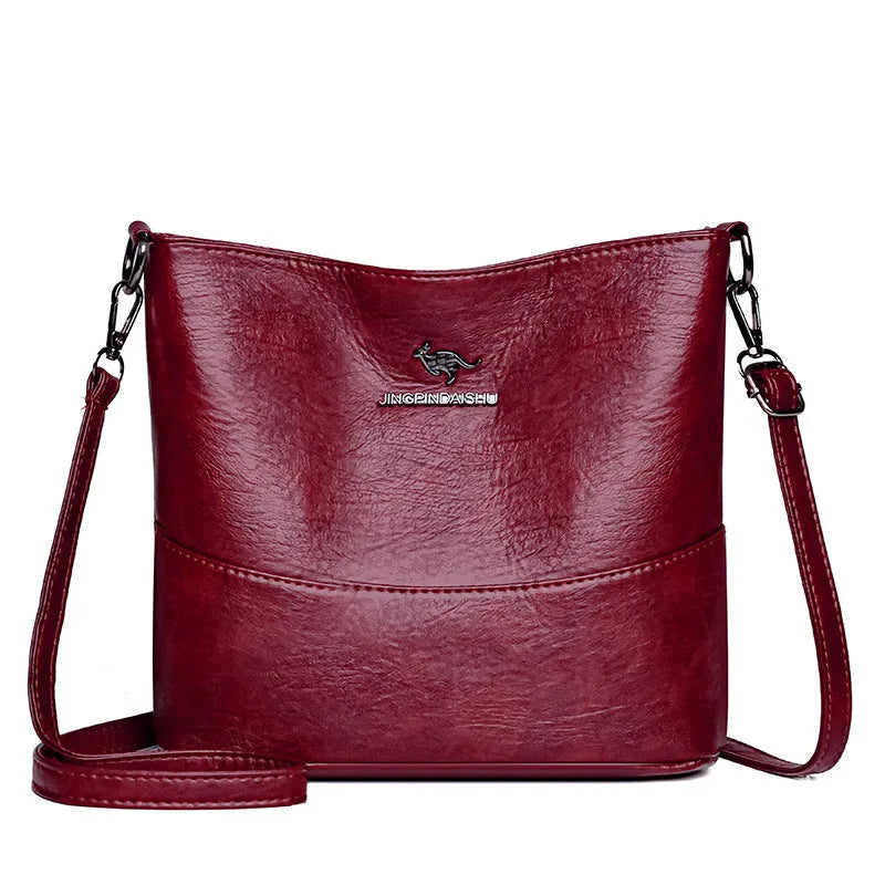 Women's soft leather bucket shoulder bag in black with visible sewing lines and phone compartment