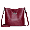 Women's soft leather bucket shoulder bag in black with visible sewing lines and phone compartment