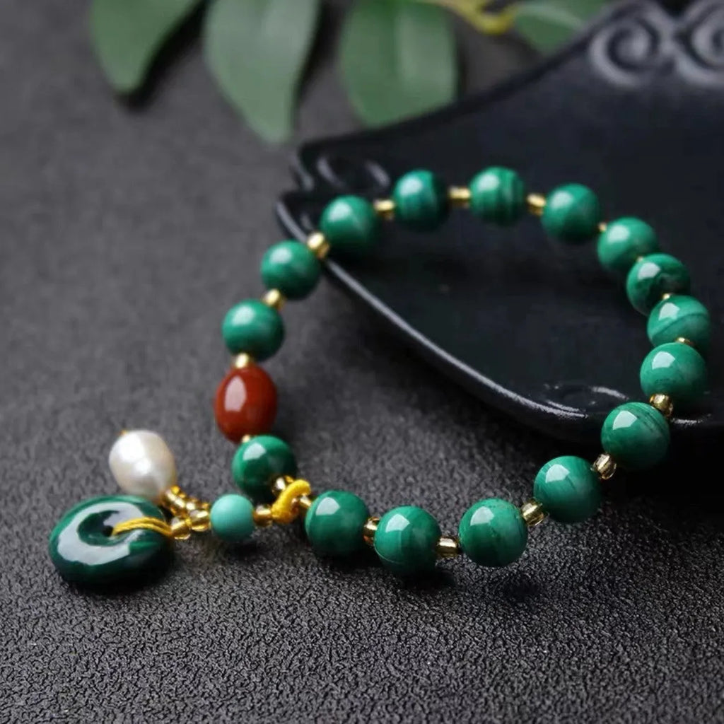 Natural green malachite and red agate barrel bead bracelet on wrist, bead size 7-8mm.
