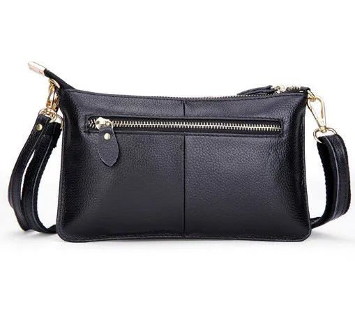Lady cowhide slant bag showing compact design with hand strap and shoulder strap options