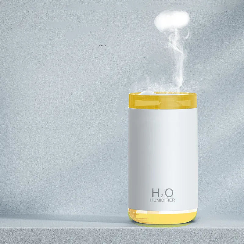 White jellyfish smoke ring humidifier with warm night light on a wooden surface