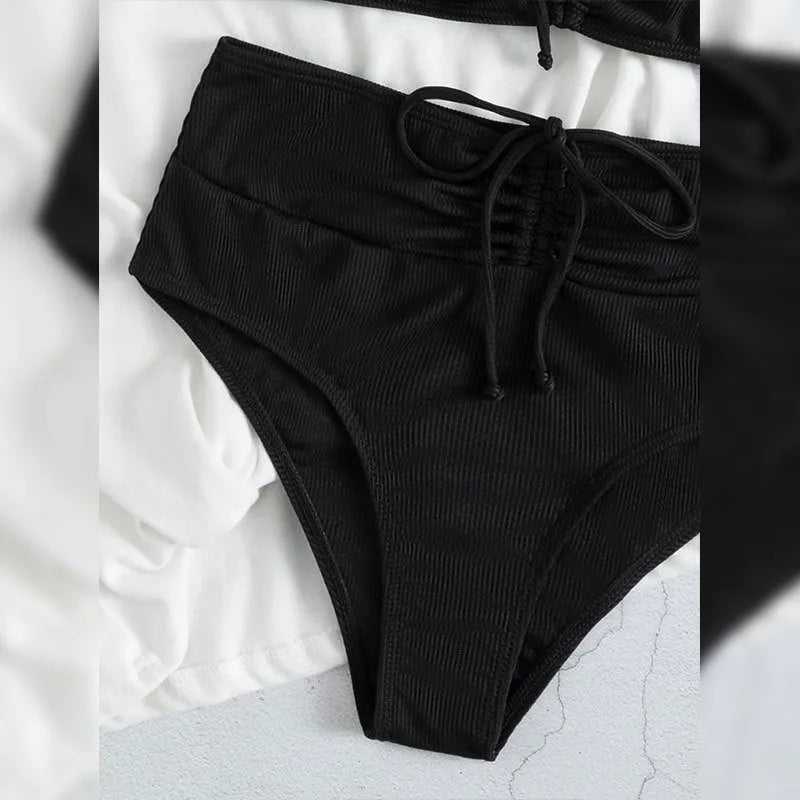 Black women's bikini swimsuit with high waist shorts and a sleeveless top on a mannequin.