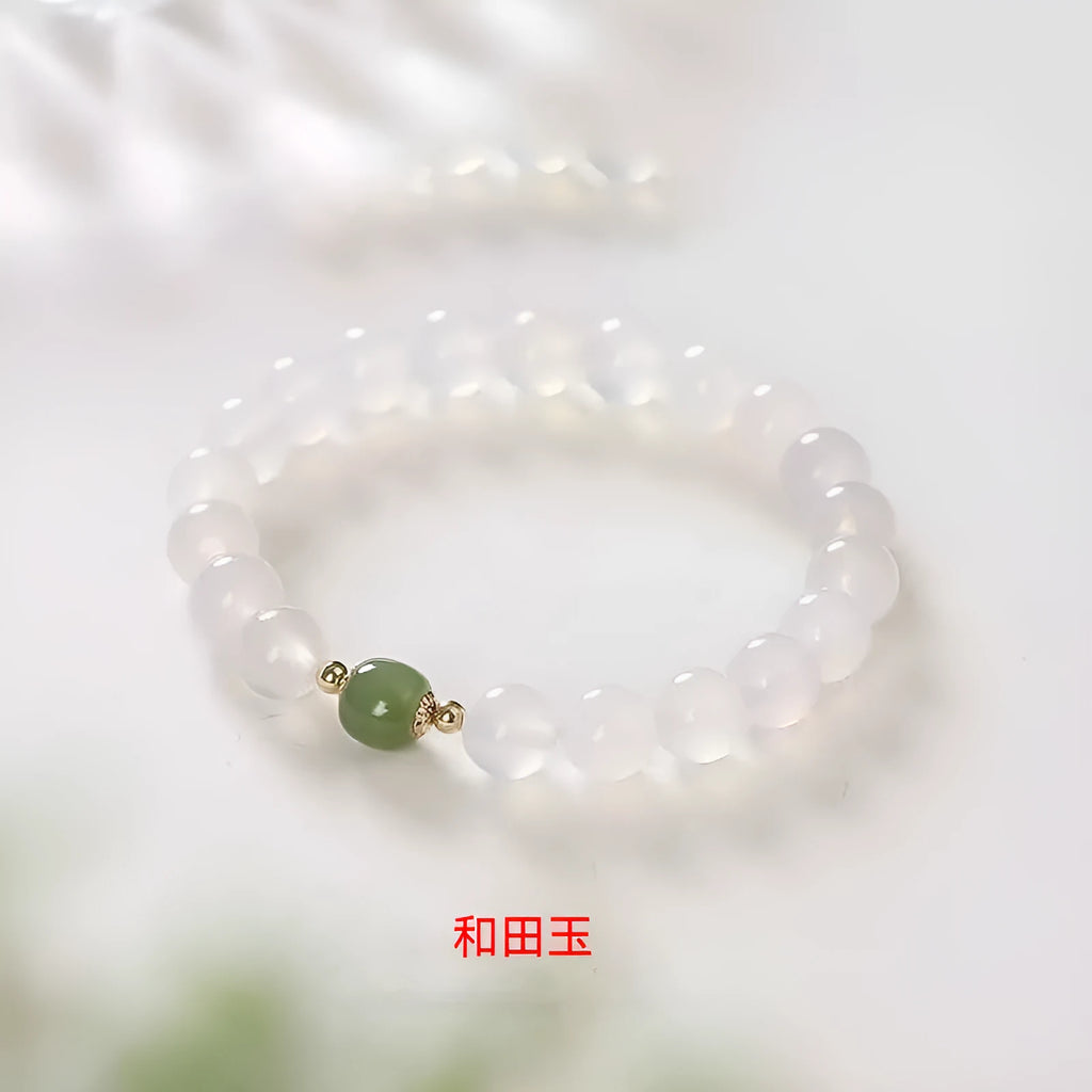 Handmade white agate and crystal bracelet with cinnabar inlay and text charm.