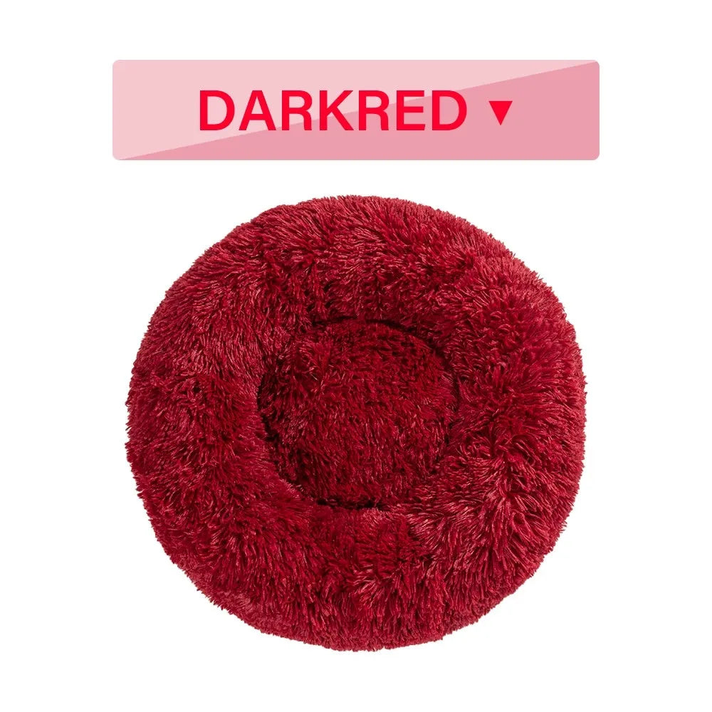 Fluffy donut-shaped dog bed in light grey plush material, showing raised rim and central cushion.