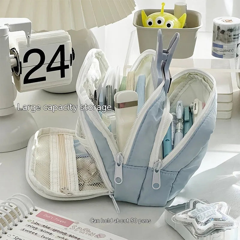 Double layer zippered pencil case in blue with an attached carry handle, showing two compartments.