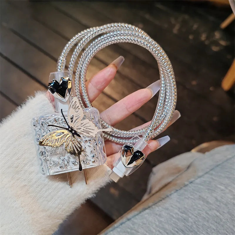 Three-dimensional butterfly USB cable protection sleeve in butterfly colour with silver foil finish on a white background