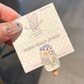 A resin hair clip shaped and coloured like a cartoon ice cream barrette, shown on a side clip.