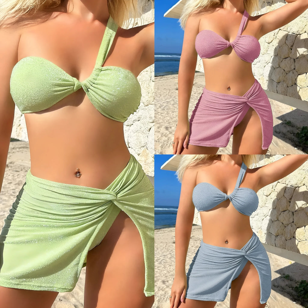 Light green one-shoulder swimsuit top with matching bikini bottoms and skirt laid flat