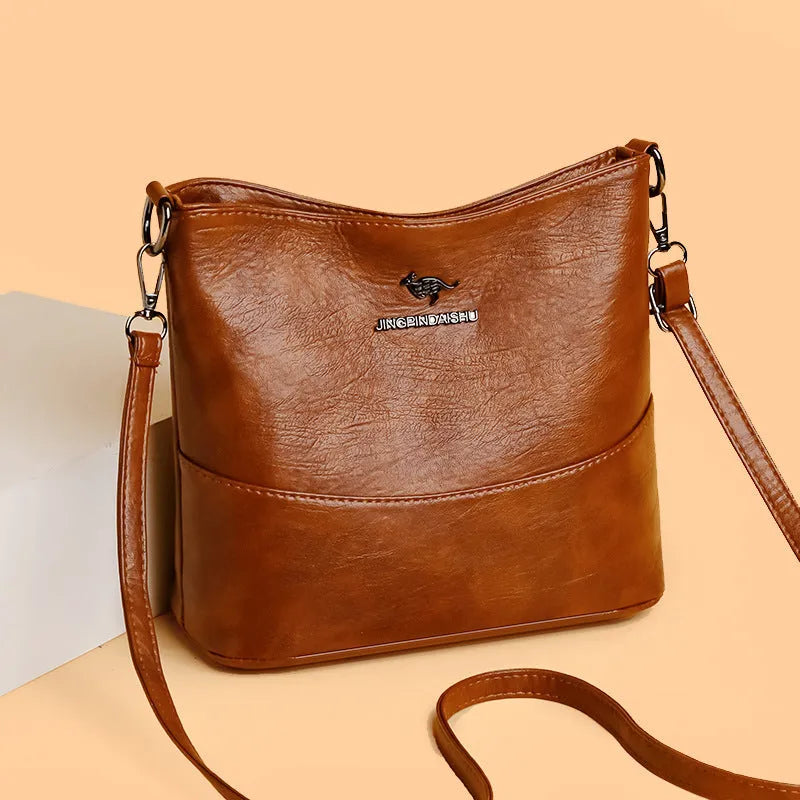 Women's soft leather bucket shoulder bag in black with visible sewing lines and phone compartment