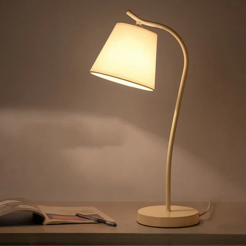 A modern LED table lamp with a push button dimmer switch on its base.