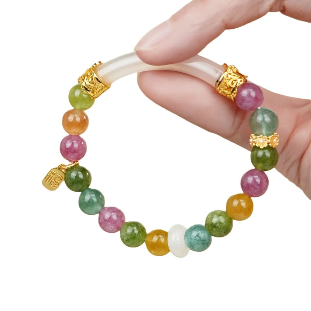 Natural rainbow-coloured tourmaline and jade half bracelet for women on a wrist.