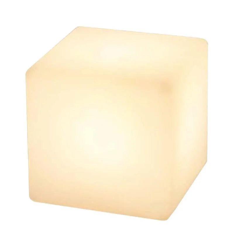 A white, square LED cube light stool with a modern design, shown outdoors on a patio.