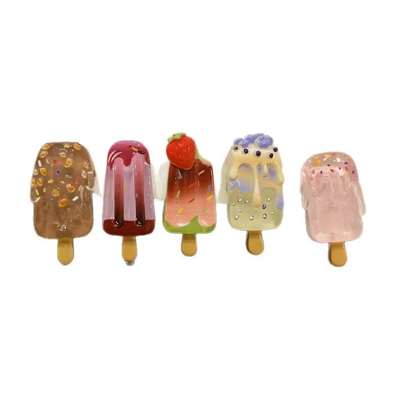 A resin hair clip shaped and coloured like a cartoon ice cream barrette, shown on a side clip.