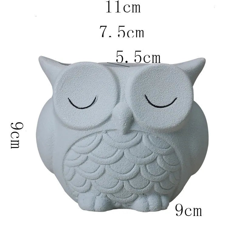 Handmade frosted ceramic owl succulent pot in pastel colour on a wooden surface.