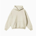 Man wearing a grey apricot loose-fit hooded sweater with drop-shoulder sleeves.