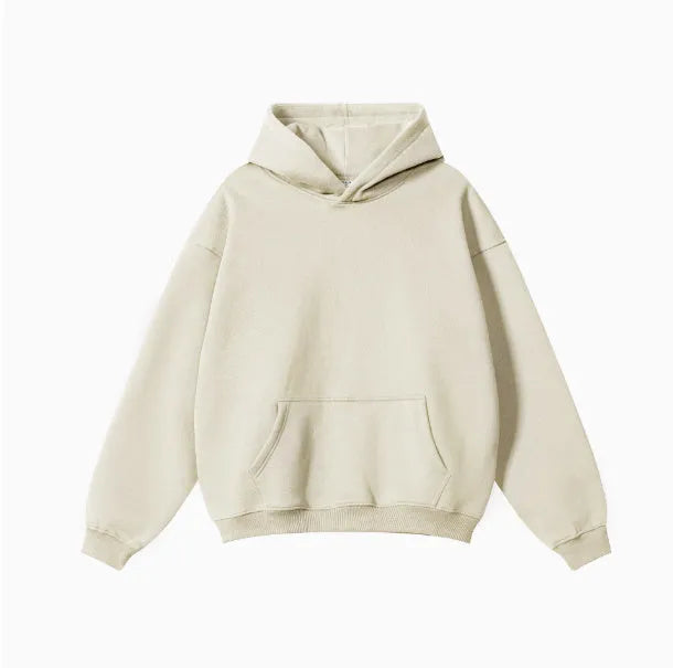Man wearing a grey apricot loose-fit hooded sweater with drop-shoulder sleeves.