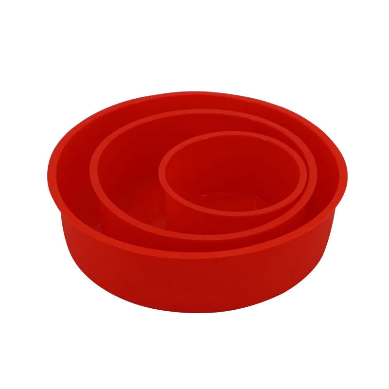 Set of three round red silicone cake moulds in 4-inch, 6-inch, and 8-inch sizes on a baking tray.