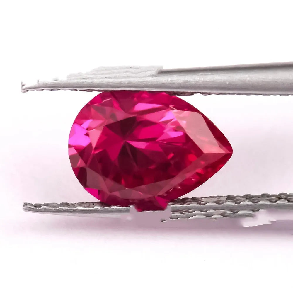 Cultivated ruby gemstone in various cuts including round, princess, oval and pear shapes on white background.