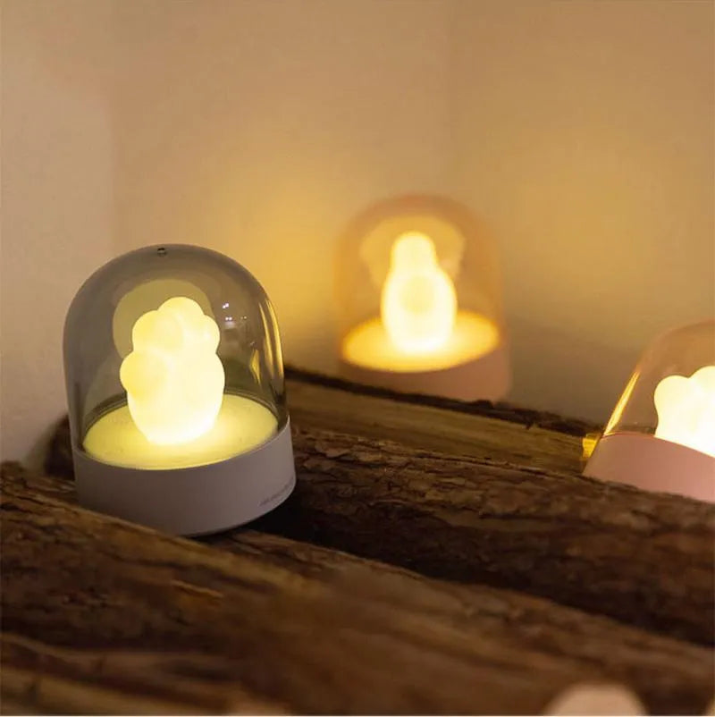 Grey cat paw shaped USB rechargeable night light with music box function on wooden desktop
