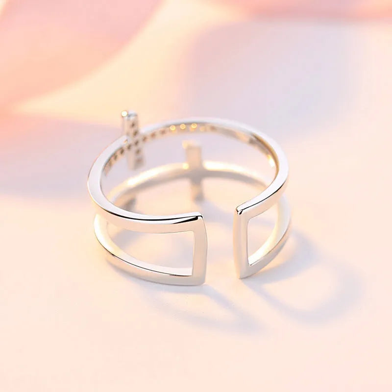 Adjustable double cross geometric ring in white gold colour with zircon stones in a sterling silver inlay.