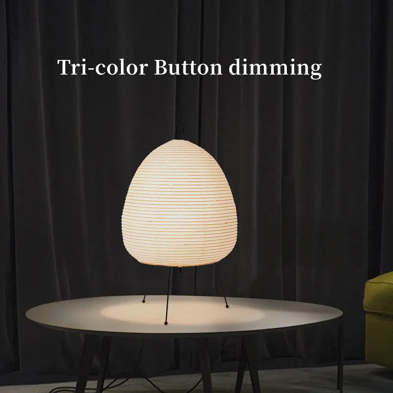 Japanese style table lamp with handmade paper shade and aluminium base on a wooden surface.