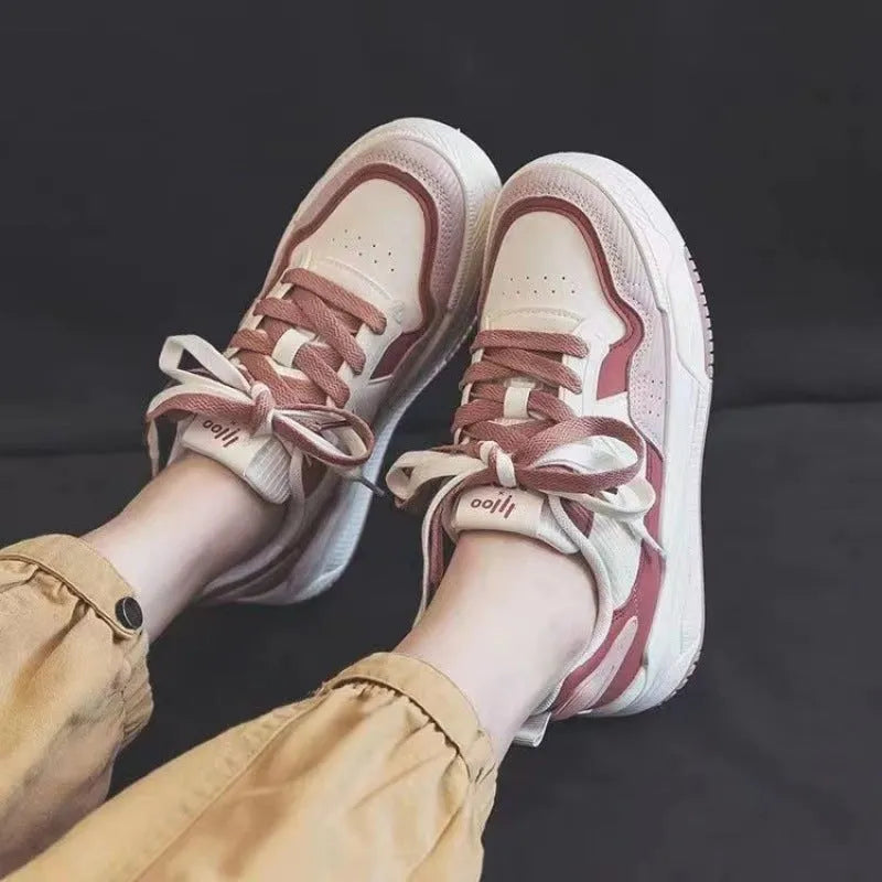 Women's pink and beige low-top sneakers with a rubber sole for height increase.