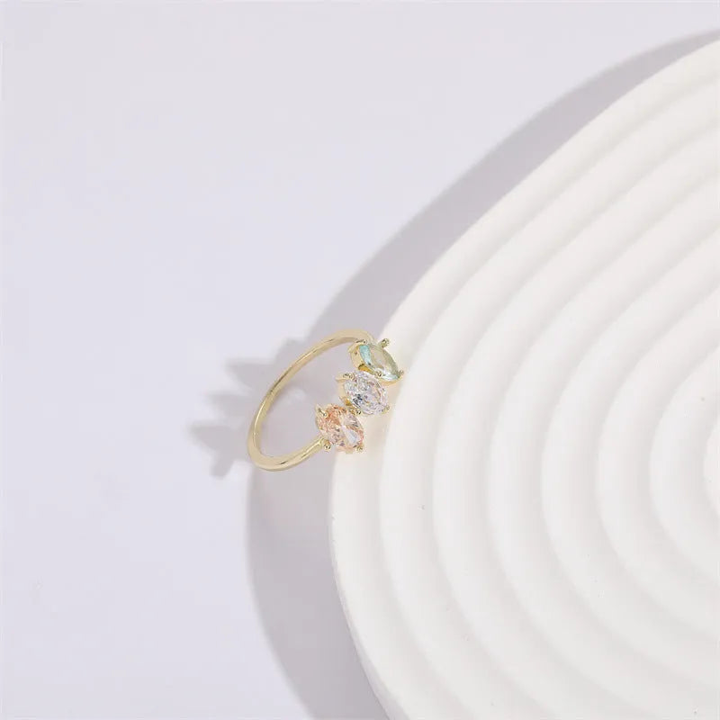 Geometric triangle copper ring with horse eye motif, tricolor zircon, and gold electroplate finish.