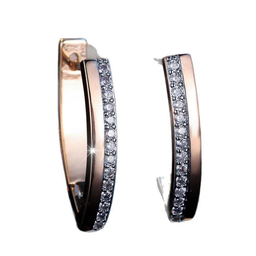 Women's geometric V-shape ear clips in champagne gold with white diamond detail on copper construction